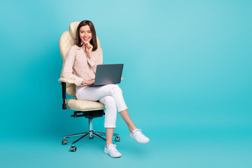 Fototapeta na wymiar Full length photo size photo of businesswoman sitting chair touch chin using netbook positive smile empty space proposition isolated on blue color background