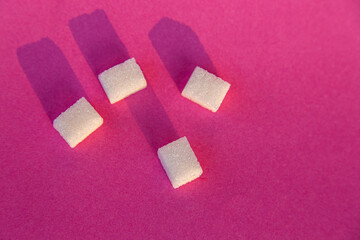 4 Cubes of shugar on a pink background with shadow 