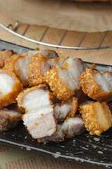 crispy pork belly deep fried pork or Chinese roasted pork belly on a wooden chopping board. close-up shot