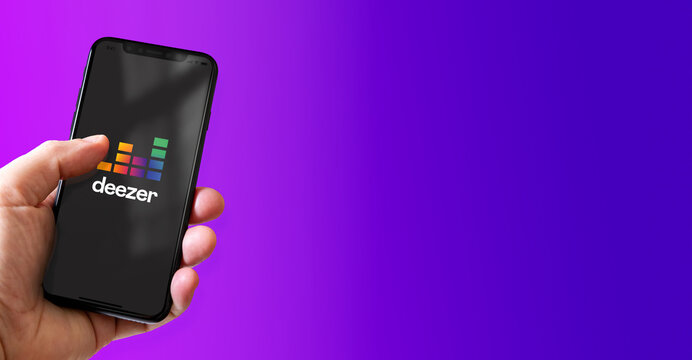 Hand holding iphone smartphone with Deezer logo, Paris, France