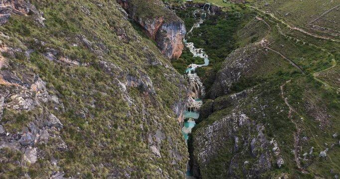 Amazing aerial zoom out shot with drone from the Andes area in Ayacucho Peru, of the famous turquoise Lake Millpu located between mountains.