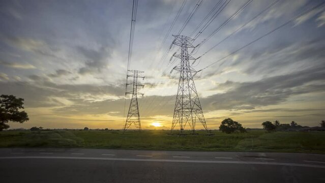 4k time lapse of sunset with transmission electricity steel pylon tower. Green energy sustainability and renewable concept. 
