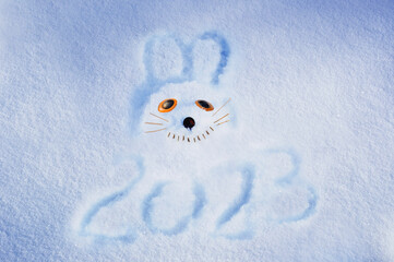 A smiling rabbit is painted on sparkling snow. Symbol of 2023. Chinese New Year. Greeting card...