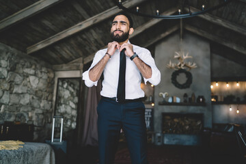 Businessman in elegant outfit fixing black tie
