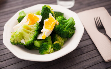 healthy food. steamed broccoli inflorescences with boiled egg in a bowl
