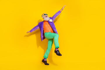 Full length photo of dreamy attractive man wear purple velvet jacket having fun discotheque hands sides isolated yellow color background