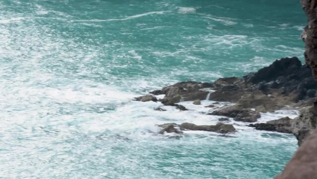 Waves crashing rocks in Orkains Bay, Akaroa Head, New Zealand