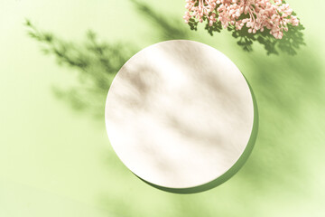 Empty white circle mockup podium for product presentation on a blooming spring flower background...