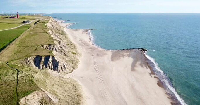 flight along the coastline from the North Sea with cliff and beach towards the famous Bovbjerg Fyr lighthouse, Jutland, Denmark, high quality video
