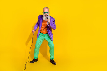 Full length photo of attractive funky guy dressed violet velvet jacket singing songs empty space isolated yellow color background