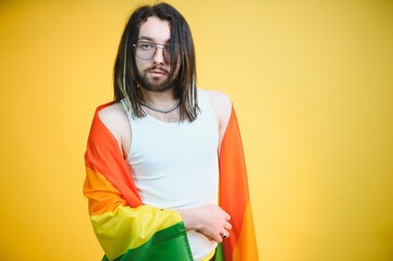 Young gay man is standing in the studio and posing for a camera.