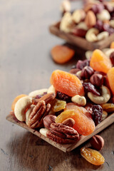 Mix of nuts and dried fruits on an old wooden table.