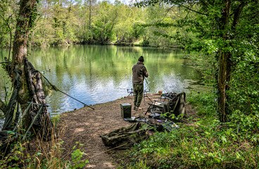 Fototapeta na wymiar Fisherman by the lake side at Swanick Lakes nature reserve.