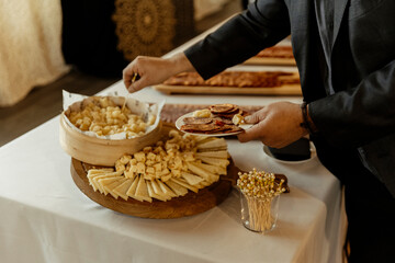 close up view of a man taking cheese from a caterer during an event
