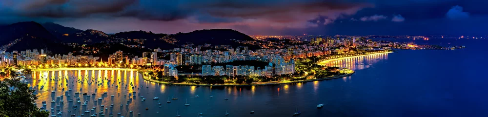 Zelfklevend Fotobehang Panoramic photograph of the shore of Guanabara Bay in Rio de Janeiro at night with the buildings and citylights in Botafogo and Flamengo neighborhoods and the hills in the background © Fred Pinheiro