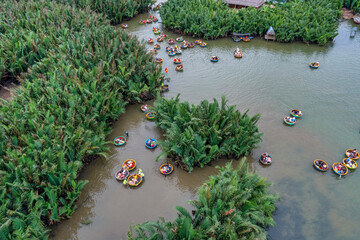 Fototapeta na wymiar AERIAL VIEW, TOURISTS FROM THAILAND, KOREA, AMERICA AND JAPAN ARE RELAX AND EXPERIENCING A BASKET BOAT TOUR AT THE COCONUT WATER ( MANGROVE PALM ) FOREST IN CAM THANH VILLAGE, HOI AN,QUANG NAM,VIETNAM