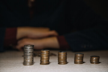 saving money hand putting coins on stack on table with sunshine. concept finance and accounting