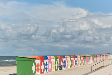 Colorful beach huts in front of historic seaside buildings at Malo-Les-Bains beach in Dunkirk,...