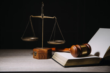 Justice and law concept.Male judge in a courtroom with the gavel, working with, computer and docking keyboard, eyeglasses, on table in morning light