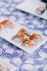 Man eating sushi set with chopsticks on restaurant