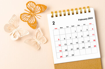 A February 2023 desk calendar for the organizer to plan and reminder and butterfly paer on yellow background.