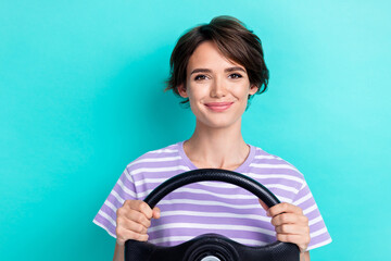 Photo of cheerful good mood woman with bob hairstyle wear striped t-shirt arms hold steering wheel isolated on teal color background