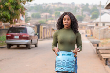 young nigerian woman carrying a gas cylinder