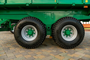 Chassis with wheels for commercial cargo transportation. Traffic safety. A large black rough tire for trucks. Working in a quarry with crushed stone and coal.