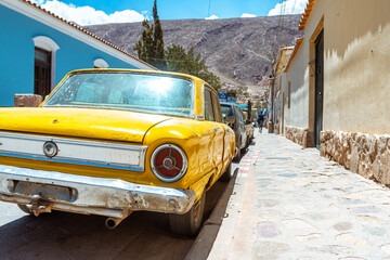 retro car parked at tilcara town, argentina - obrazy, fototapety, plakaty