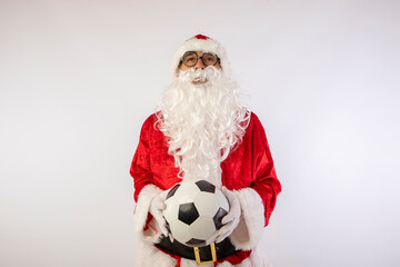 Santa Claus with glasses holding a World Cup soccer ball as a gift for all children, with a white background where his red suit and white beard stand out