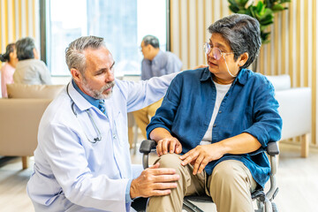 Orthopedist examines the knee of elderly patient to collect information for physical therapy...