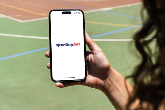 Girl holding an iPhone 14 Pro smartphone with Sportingbet betting provider app on screen. Multi-sport court in the background. Rio de Janeiro, RJ, Brazil. November 2022