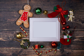 Christmas background blank frame for text with decorations on dark wooden board.