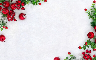 Christmas decoration. Branch christmas tree, red berries, red apples on snow with space for text. Top view, flat lay