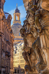 Cityscape - street view with sculptures of gatekeepers on the George Gate of Dresden Castle against...