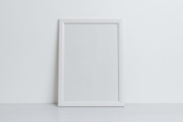 White picture frame mockup leaning against the wall. Clean, blank surface for art presentation