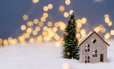 Fototapeta na wymiar Christmas tree and house in the snow. Bokeh light banner