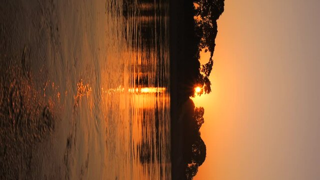 Beautiful Dramatic Orange Sunset with Water Sun Reflection High Quality 4K Slowmotion Vertical Stories Footage. Mekong River, Laos.