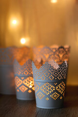 Decorative candle holders on the table, bokeh lights in the background. Selective focus.