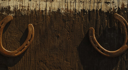 Western industry background with old used rusty horseshoes on wood texture with copy space.