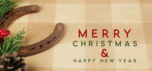 Western industry Merry Christmas greeting with old horseshoe on tan plaid background for holiday.