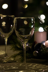 Serving the festive table. Food and drinks, plates and glasses. Evening lights and candles. Christmas dinner on Christmas Eve and New Year's Eve. photography in a dark key.