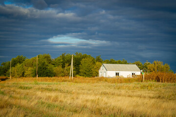 White house in norway. Lonely house in field in Scandinavian style at sunset.