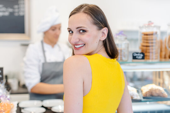 Woman in the pastry shop choosing sweet desserts with anticipation