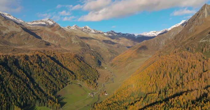 Colourful golden autumn Casere alpine valley below South Tyrol high mountains aerial view at sunrise