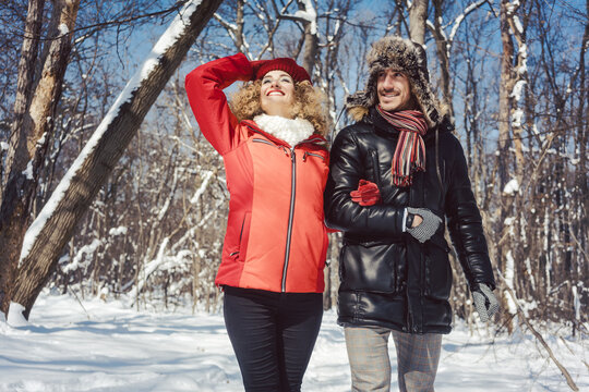Couple of woman and man enjoying a day out in winter season in warm clothing