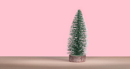 Mini Christmas tree on pink pastel background. Minimal trendy Christmas decoration. 
