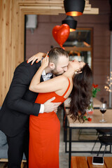 Romantic couple standing in restaurant on a date and hugging