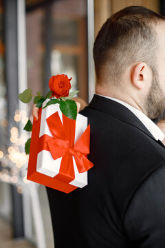 Cropped photo of man in restaurant with his girlfriend holding dift box