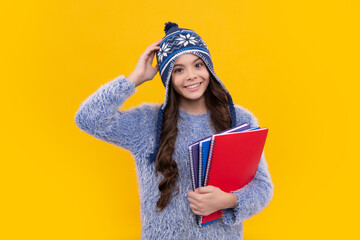 Funny school girl child student with book and warn hat, isolated yellow background. Learning and knowledge education concept. Autumn school.